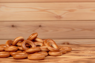 Heap of bagels scattered on the wooden table with copy space