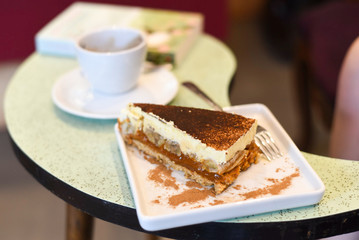 piece of pie on a green table with a cup of coffee and a book