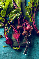 Großaufnahme von frischen reifen ungekochten roten Rüben (rote beete )auf blauer Oberfläche