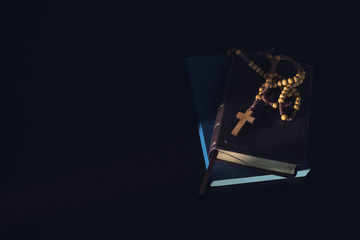 Bible and christian study concept. Wooden Christian cross necklace on holy Bible.