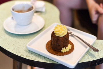 cake with a cup of coffee on a green table