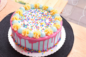 Colorful cake with confetti in a wood table