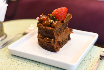 chocolate cake with strawberry on a white plate