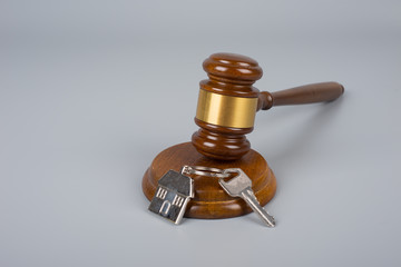 House keys and judge's gavel on a gray background. Concept purchase sale, rent, auction, mortgage....