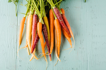 top view of various fresh carrots on wooden surface
