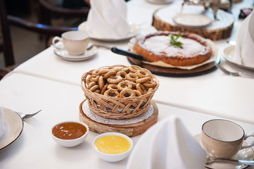 Traditional russian baked goods: pies and pretzels, samovar, honey, jam on the served table