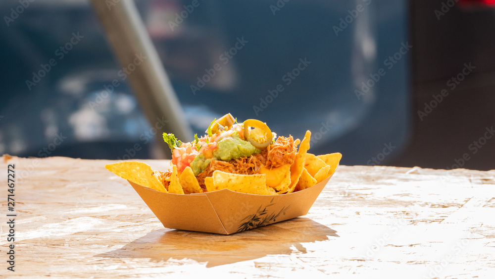 Wall mural plate of nachos with ground meat and salsa topped with cheese mexican food truck on festival