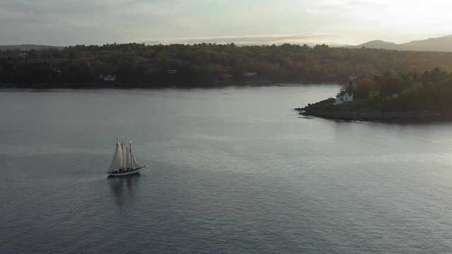Flying around a schooner sailing around the Curtis Island Lighthouse AERIAL