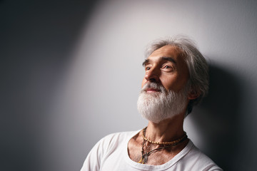 Studio portrait of handsome senior man with gray beard.