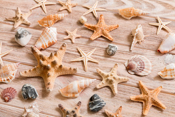 Fototapeta na wymiar Starfish and seashells background on a wooden table, top view, flat lay