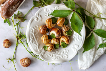 Bourguignonne snail with lemon. Marble background. French cuisine.