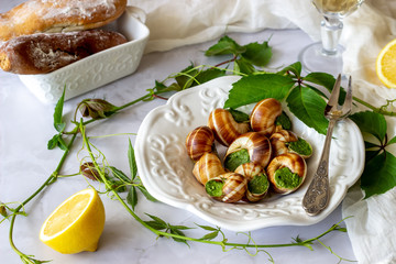 Bourguignonne snail with lemon. Marble background. French cuisine.