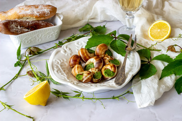 Bourguignonne snail with lemon. Marble background. French cuisine.