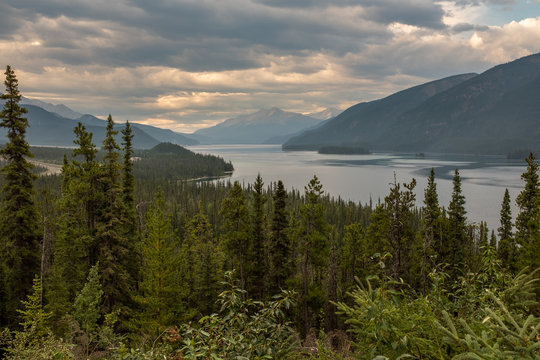A view from the road of the beautiful Muncho Lake in Canada framed by the pine forests, nobody in the image