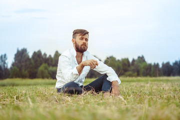 Naklejka na ściany i meble the guy with the beard sitting on the grass