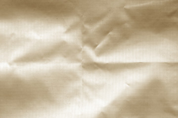 Crumpled transparent plastic surface in brown color.