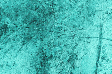 Vintage azure background. Rough painted wall of turquoise color. Imperfect plane of cyan colored. Uneven old decorative toned backdrop of aqzure tint. Texture of teal hue. Ornamental stony surface.