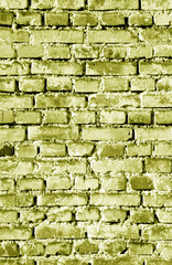 Old grungy brick wall surface in yellow tone.