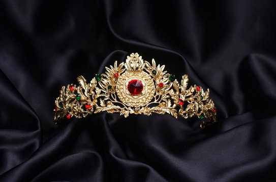 golden crown with rubies  on a black silk