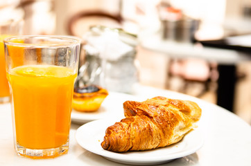 morning breakfast croissant and fresh orange juice on table