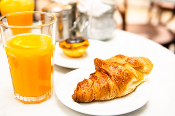 morning breakfast croissant and fresh orange juice on table