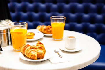 morning breakfast croissant, coffee and fresh orange juice on table