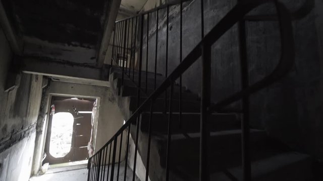 Shaky camera comes towards damaged staircase leading nowhere. Exploring of abandoned place full of debris. Bad dream and nightmare scene concept. Slow motion. Explosion