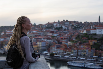 Fototapeta na wymiar Young woman with dreadlocks on view point opposite Ribeira on Douro river, Porto, Portugal.
