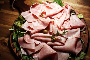 Sliced ham on wooden background. Fresh prosciutto. Pork ham proscuitto sliced.