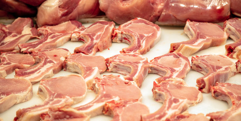 Meat concept. Raw pork loin chops at butcher shop. Uncooked steaks for background, closeup, above view.