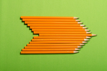 Yellow pencil isolated on green background. Minimalist template with copy space.