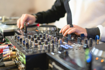 Dj hands on a mixing console. Nightlife concept