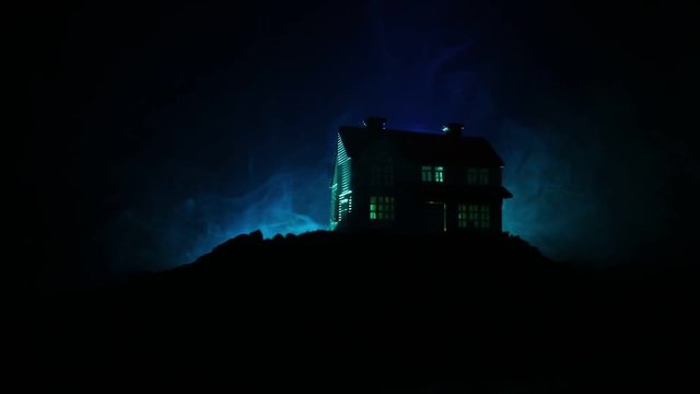 Old house with a Ghost in the forest at night or Abandoned Haunted Horror House in fog. Old mystic building in dead tree forest. Trees at night with moon. Surreal lights. Horror Halloween concept