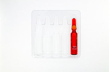 ampoule with red liquid in a transparent package - 271484015