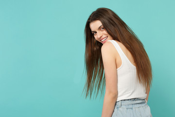 Back rear view of laughing funny young woman in light casual clothes looking back isolated on blue...