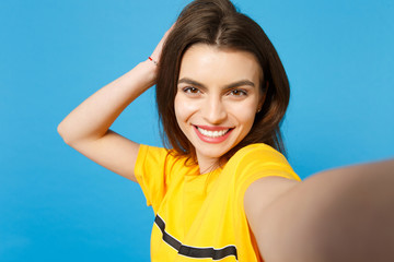 Close up selfie shot of smiling stunning charming young woman in vivid casual clothes looking...