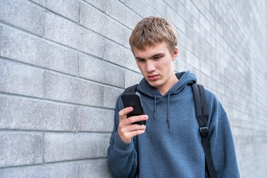 Teenager viewing something upsetting on his cellphone.