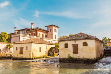 Fototapeta na wymiar Cityscape of Portogruaro in Veneto Italy with lemene river, tower and mills