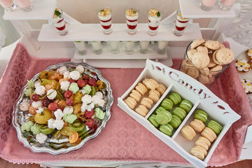 Candy bar on the table with a sweets, fruits, macaroons and other desserts