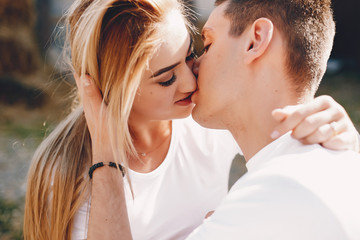 Fototapeta premium Cute couple in a park. Lady in a white t-shirt. 