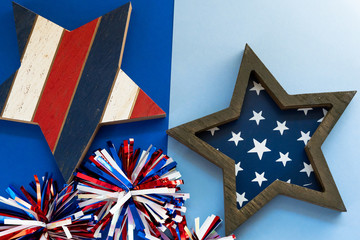 Festive Fourth of July flatlay concept with wooden stars, and shiny pom poms, useful for patrotic USA themed backgrounds
