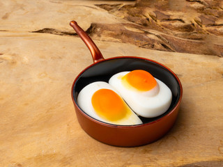 Children's toy skillet fried eggs on a wooden background isolation