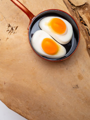 Children's toy skillet fried eggs on a wooden background isolation