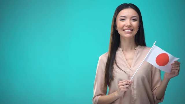 Smiling lady holding Japan flag ready to learn foreign language, Japanese school