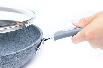 Stylish frying pan in hands on a white background