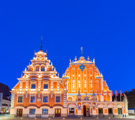 Fototapeta na wymiar House of the Blackheads (Melngalvju nams) - ornate historical building on Town Hall Square in Riga, the capital of Latvia, at night, artificially illuminated, under clear, dark blue sky. Copy space.