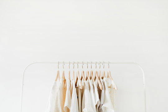 Minimal fashion clothes concept. Female blouses and t-shirts on hanger on white background. Fashion blog, website, social media hero header template.