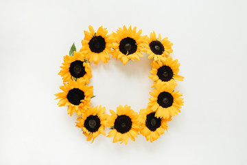 Wreath frame made of sunflowers with copy space on white background. Flat lay, top view summer floral mock up template.