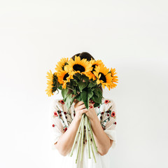 Young pretty woman with sunflowers bouquet on white background.