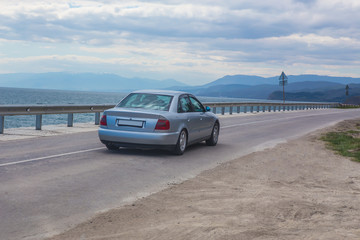 Obraz premium Car moves on the highway along the sea